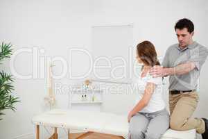 Osteopath looking at the back of a woman