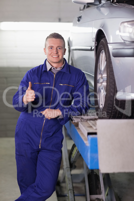 Man standing next to a car with his thumb up
