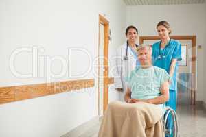 Patient in a wheelchair next to nurses