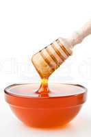 Honey dipper on top of a honey bowl