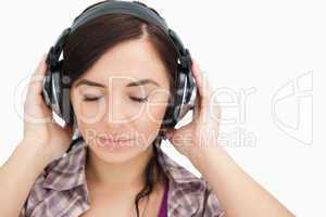 Brunette with headphones closing her eyes