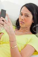 Portrait of a sad Latino holding her smartphone