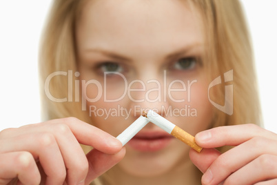 Close up of a young woman breaking a cigarette