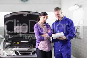 Mechanic showing a clipboard to a client
