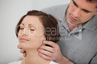 Physiotherapist massaging the neck of a patient