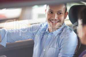 Man smiling while sitting in a car