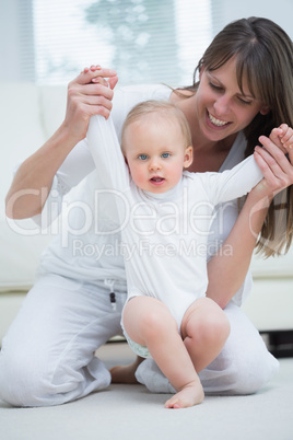 Mother raising arms of her baby