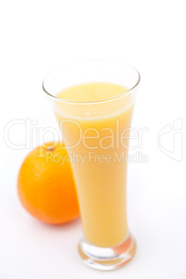 Orange behind a full glass of orange juice