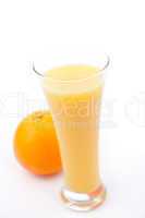 Orange behind a full glass of orange juice