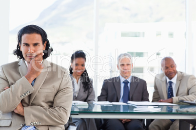 Serious businessman with his hand on his chin sitting in front o