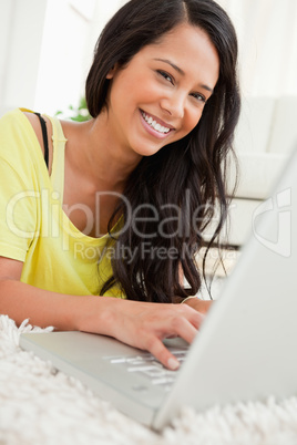 Portrait of a beaming Latin chatting on a laptop
