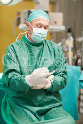 Surgeon putting on surgical gloves