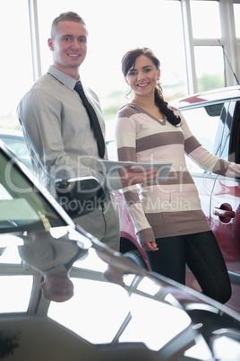 Salesman and a woman standing next to a car
