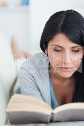 Woman reading a book while relaxing on a couch