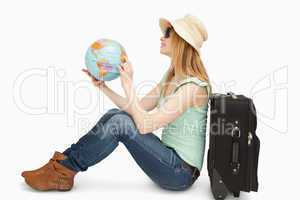 Woman sitting while holding a world globe
