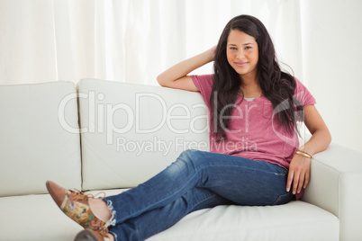 Portrait of a Latino student sitting on a sofa