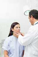 Doctor touching the neck of a patient