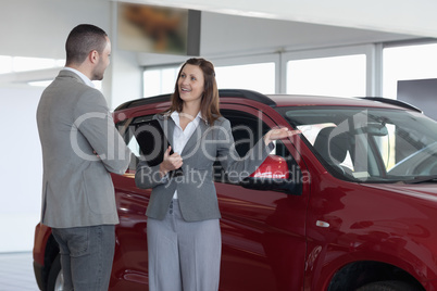 Businesswoman showing a car to a client