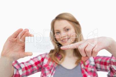 Woman holding a blank card while showing it