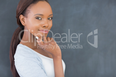 Black woman looking at camera while holding a chalk