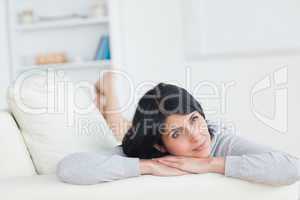 Woman laying on a sofa while holding up her head