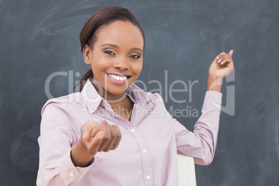 Black teacher smiling while showing the blackboard