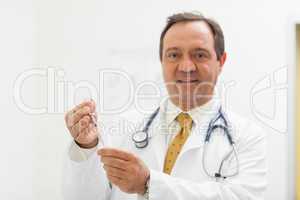 Smiling doctor preparing a syringe