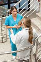 Woman nurse and doctor talking in a stairwell