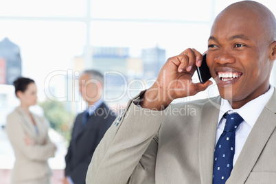 Young manager looking towards the side while talking on the phon