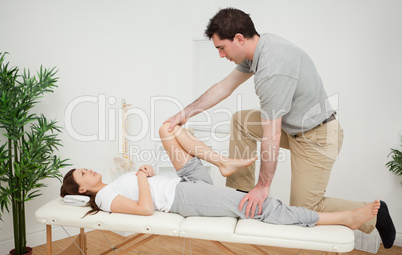 Woman being examining her leg by a chiropractor