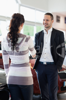 Car dealer shaking hand with a customer