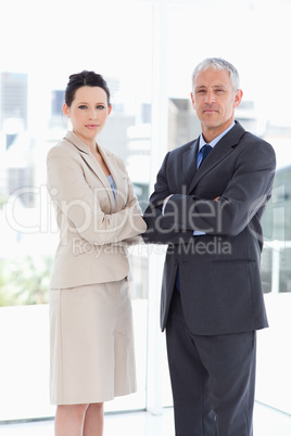 Young businesswoman standing upright with her mature director