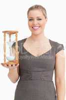 Woman smiling while holding a hourglass
