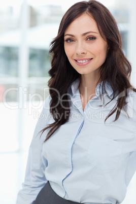 Young smiling manager standing upright in front of the bright wi