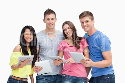 A smiling group with tablet pc's in hand as they look at the cam