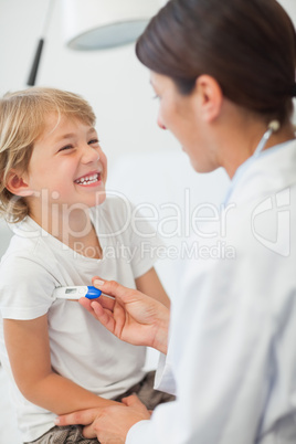 Doctor taking temperature of a child