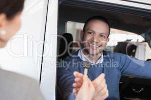 Man smiles as he takes a car key