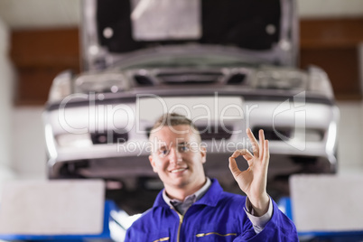Smiling mechanic doing a gesture with his fingers