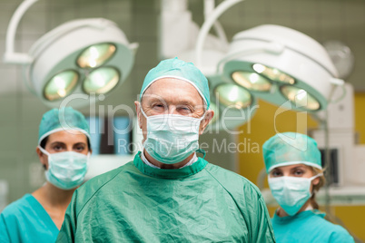 Surgeon posing with two women behind him