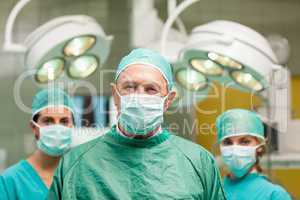 Surgeon posing with two women behind him