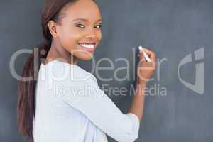 Black woman smiling while holding a chalk