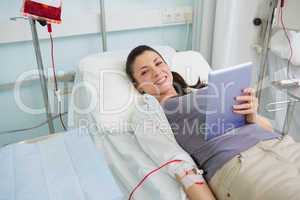 Smiling transfused holding a tablet computer