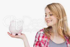 Woman looking at a piggy bank on her hand