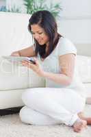 Woman holding a tactile tablet in front of a sofa