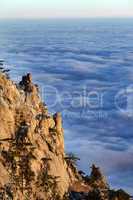 Sunlit cliffs and sea in clouds