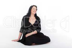 Young woman in black dress sitting on the floor
