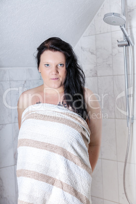 Young woman with towel in the shower