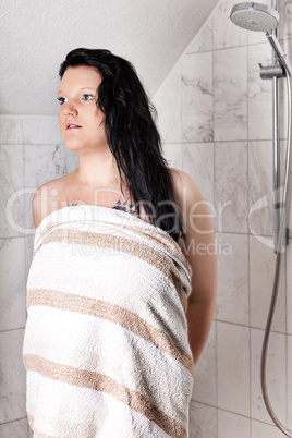 Young woman with towel in the shower