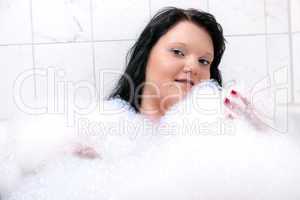 Young woman has fun in the bathtub