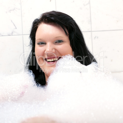 Young woman has fun in the bathtub